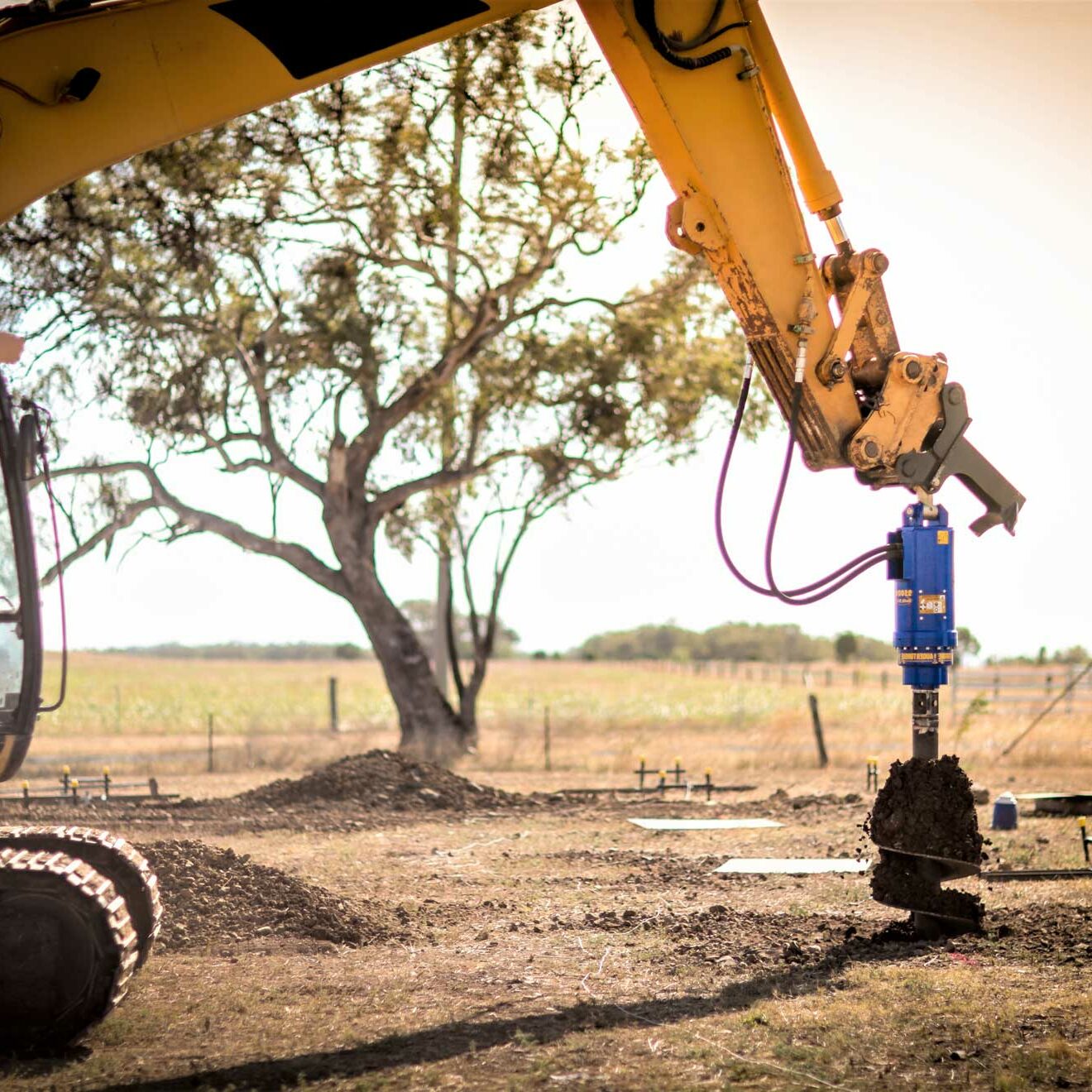 Auger Torque Earth Drill attached with an auger being used
